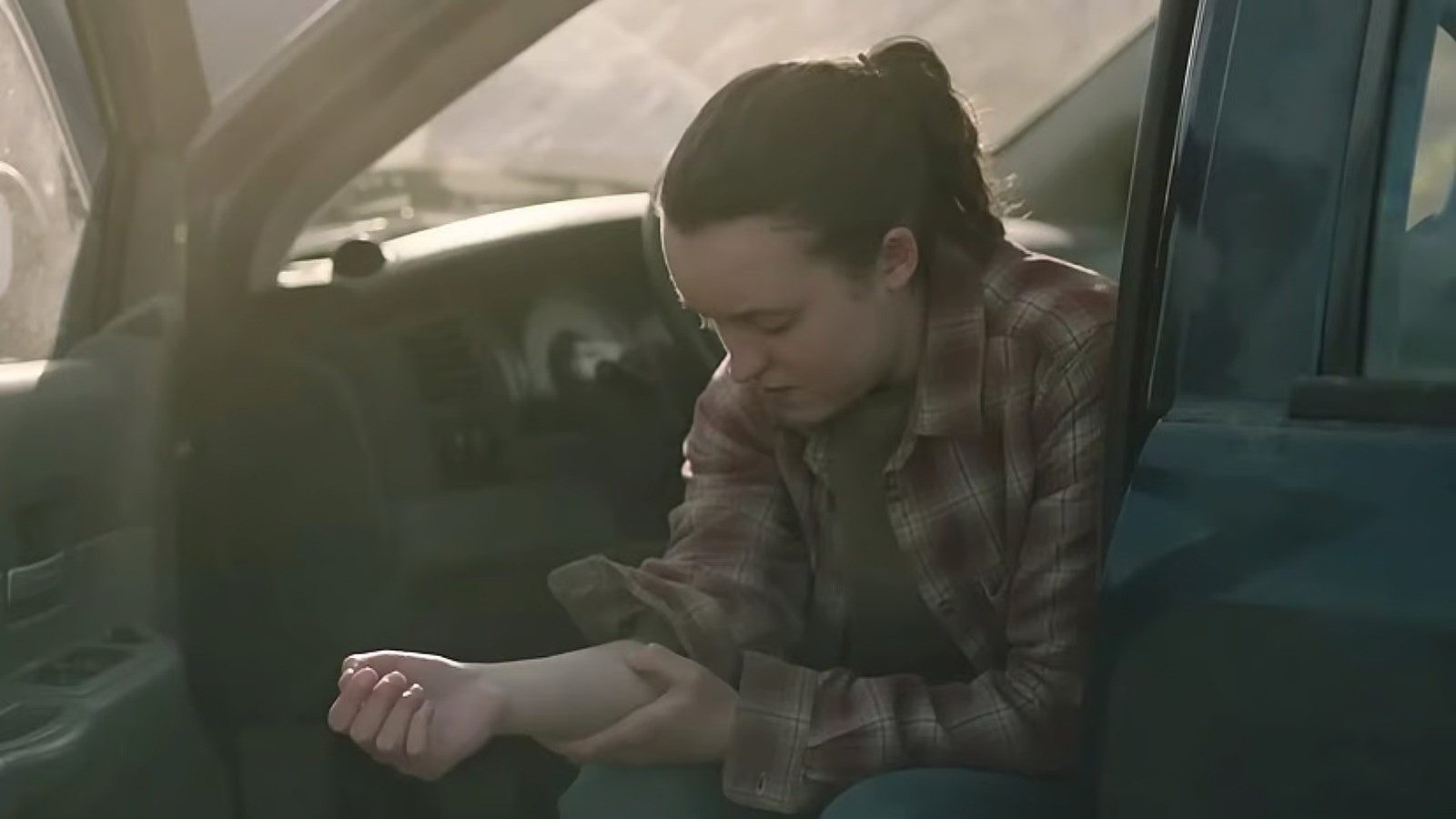 Ellie olhando para seu braço em The Last of Us