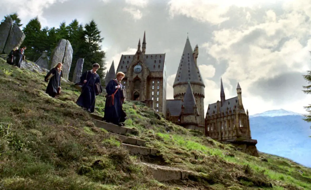 Harry, Ron e Hermione descendo escadas no exterior do castelo - Harry Potter